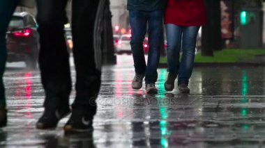 Yayalar yağmurda acele et. Ayak yayalar ıslak bir kaldırımda bir yağmur sırasında kapatın. 240 fps hızında filme