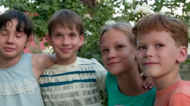 Arkadaş grubu eğlenceli hikayeler. Sarılma ve birlikte gülüyor dört arkadaş ağaçlar arka plan üzerinde eğleniyor. 240 fps hızında filme