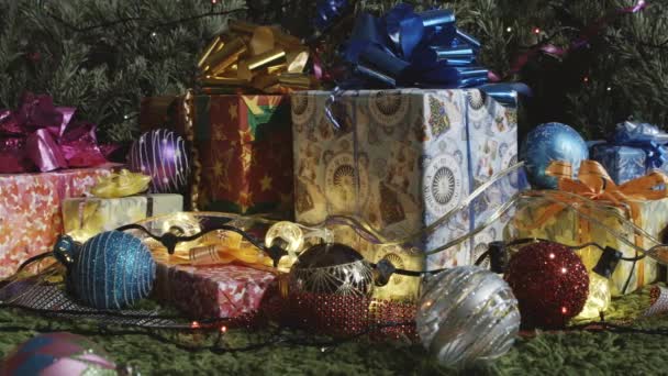 假期快到了 相机缓慢地沿着各种礼品盒移动 礼品盒上装饰着闪闪发光的弓 圣诞树装饰和闪闪发光的花环 — 图库视频影像