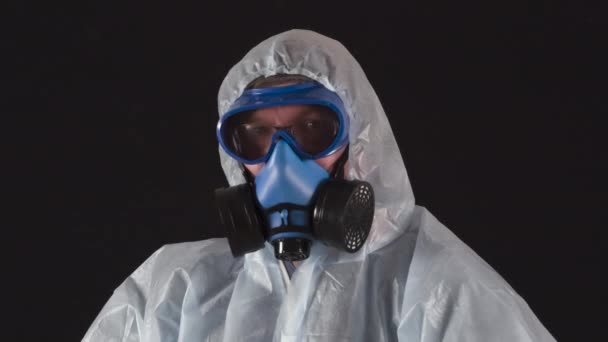 フェイスシールドを着用する必要があります 防護服の男とマスクは温度を遠隔で測定し医療マスクを保持します — ストック動画