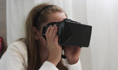 Kızı yukarıya bakıp o dokunmaya çalışan sanal gerçeklik kulaklık