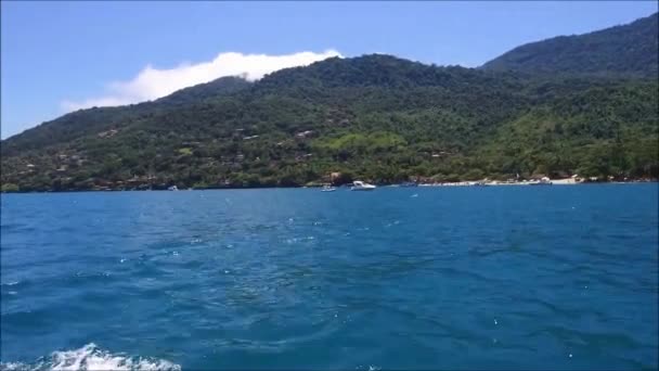 Лодка, плывущая вблизи береговой линии острова — стоковое видео