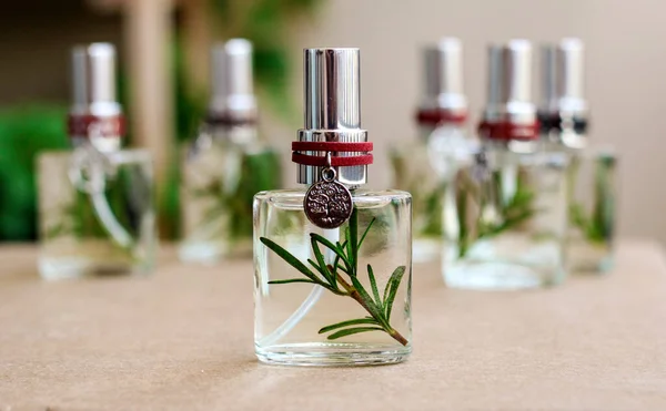 Aromatic home spray air freshener in a transparent mini glass bottle with rosemary