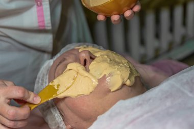Güzellik salonunda yüzüne aljinat maskeler takmak estetik bir işlemdir. Yaşlı bir kadın için yapılıyor. Deri turgor, yenilenme ve iyileşme.