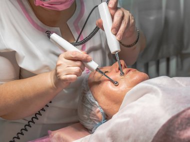 Güzellik salonunda mikro akım enjeksiyonlarıyla yapılan kozmetik bir işlem yaşlı bir kadın için yapılır. Deri turgor, yenilenme ve iyileşme.