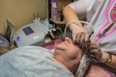 Lazer yüz temizleme işlemi yaşlı bir kadın için yapılır. Derinin yüzeyinde enstrümantal bir etki var. Deri turgor, yenilenme ve iyileşme.