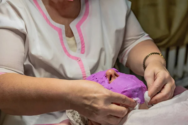 Cosmetic procedure with laying alginate masks on the face in a beauty salon. It is performed for an age woman. Improving skin turgor, rejuvenation and healing.