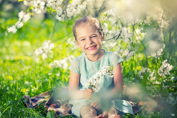 Szczęśliwa dziewczynka w ogrodzie kwiat wiśni — Zdjęcie stockowe