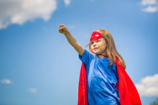 Vicces kis lány játszik a hatalom a szuperhős. — Stock Fotó