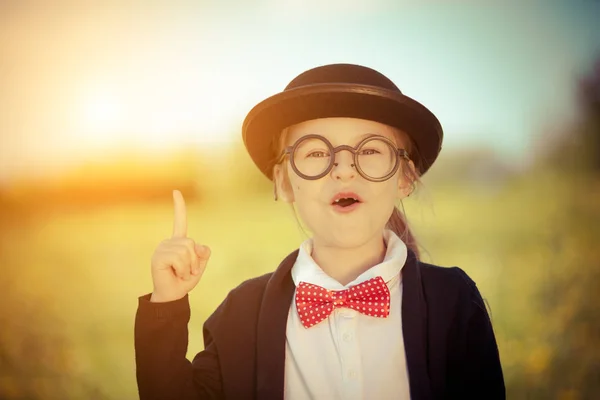 Petite fille drôle dans des lunettes, noeud papillon et chapeau melon . — Photo