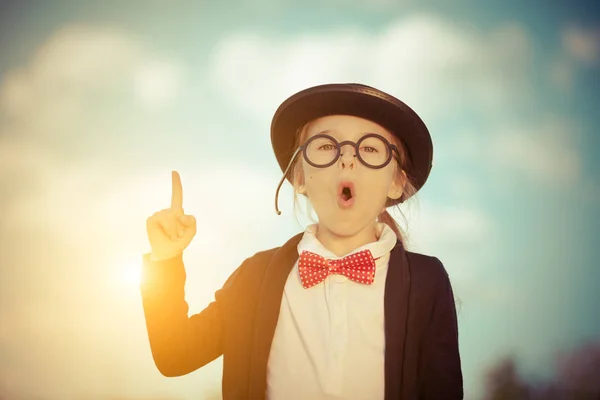 Funny little girl in glasses, bow tie and bowler hat. — Stock Photo, Image