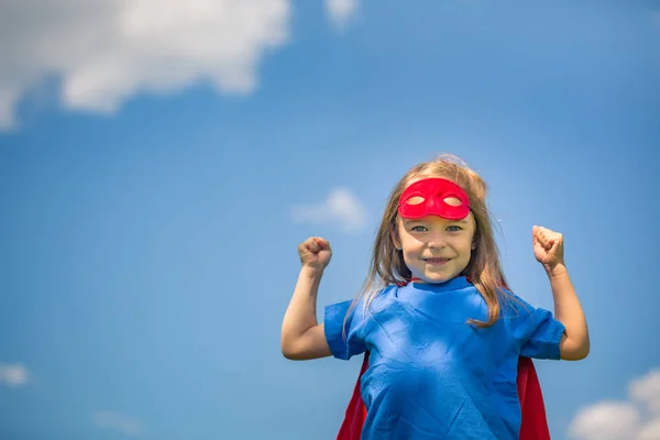 Lustiges kleines Mädchen spielt Power Superhelden. — Stockfoto