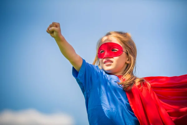 Lustiges kleines Mädchen spielt Power Superhelden. — Stockfoto