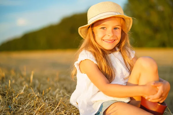 Маленькая девочка в поле с сенокосами — стоковое фото