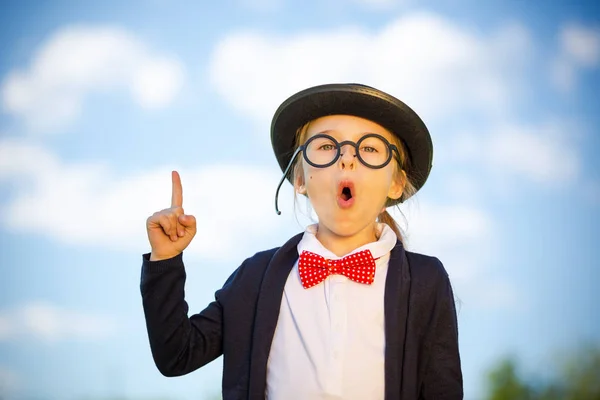 Funny little girl in glasses, bow tie and bowler hat. — Stock Photo, Image