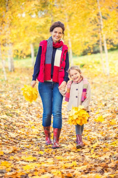 แม่และลูกสาวในสวนฤดูใบไม้ร่วง — ภาพถ่ายสต็อก