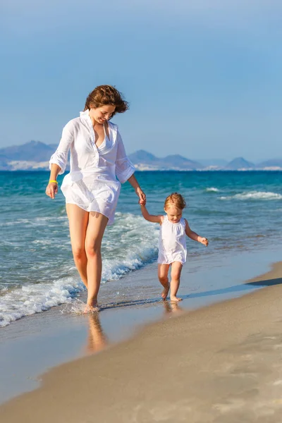 Mother and daughter walking on the beach — Stock Photo, Image