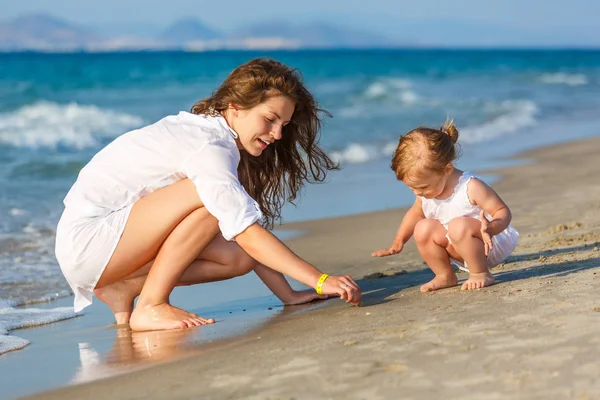 Mor och dotter leker på stranden — Stockfoto