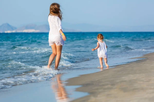 Mother and daughter walking on the beach — Stock Photo, Image