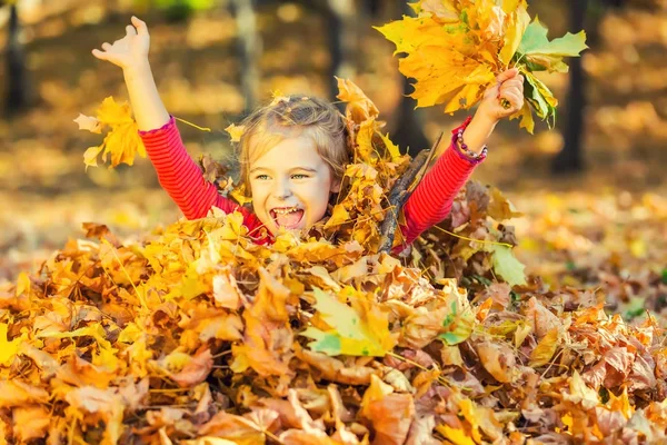 秋の紅葉の幸せな女の子を果たしています。 — ストック写真