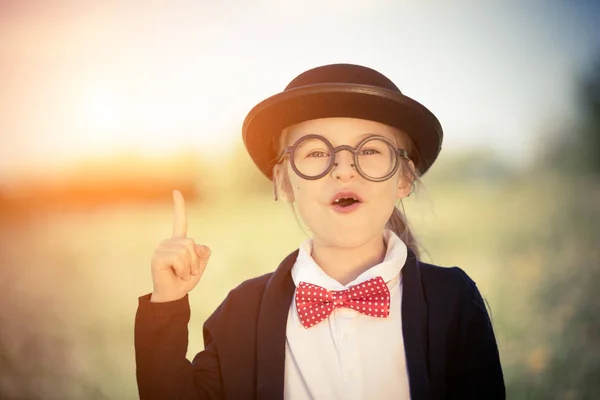 Zabawny mały dziewczyna w okulary, krawat i melonik. — Zdjęcie stockowe