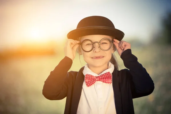 Menina engraçada em óculos, gravata borboleta e chapéu de jogador . — Fotografia de Stock