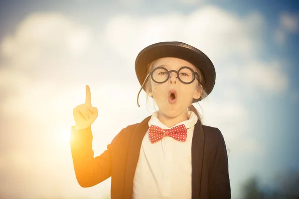 Funny little girl in glasses, bow tie and bowler hat. — Stock Photo, Image