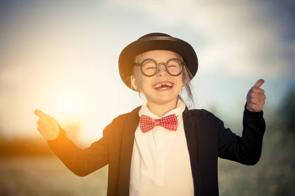 Lustiges kleines Mädchen in Fliege und Melone zeigt Daumen hoch. — Stockfoto