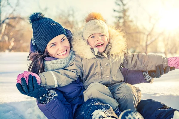 Mor och dotter leker i vinterparken — Stockfoto