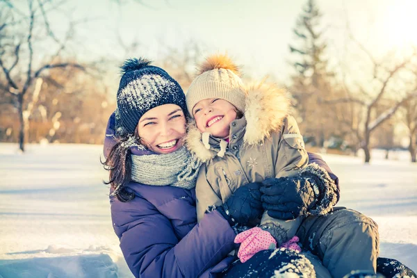 Mor och dotter leker i vinterparken — Stockfoto