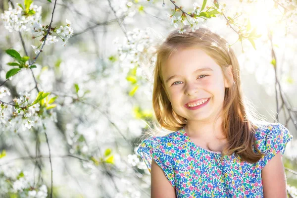 Niña feliz en el jardín de flores de cerezo —  Fotos de Stock