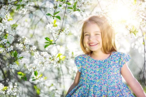 Šťastná holčička v zahradě třešňový květ — Stock fotografie