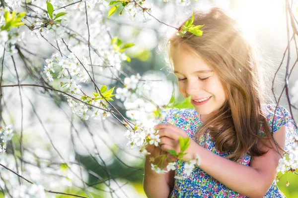Szczęśliwa dziewczynka w ogrodzie kwiat wiśni — Zdjęcie stockowe