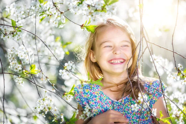 Bonne petite fille dans le jardin de fleurs de cerisier — Photo