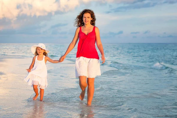 Mor och dotter går på stranden — Stockfoto