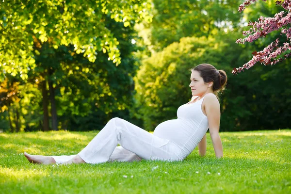 Bella donna incinta nel parco primaverile — Foto Stock