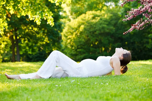 Mulher grávida bonita no parque de primavera — Fotografia de Stock