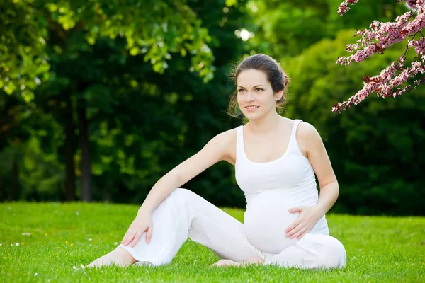 Красивая беременная женщина в весеннем парке — стоковое фото