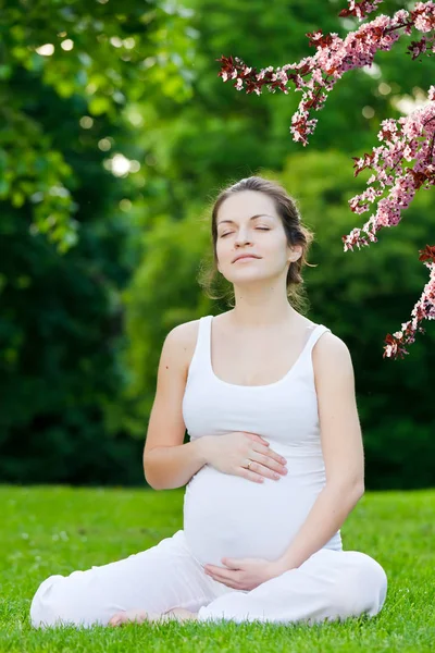 Mulher grávida bonita no parque de primavera — Fotografia de Stock