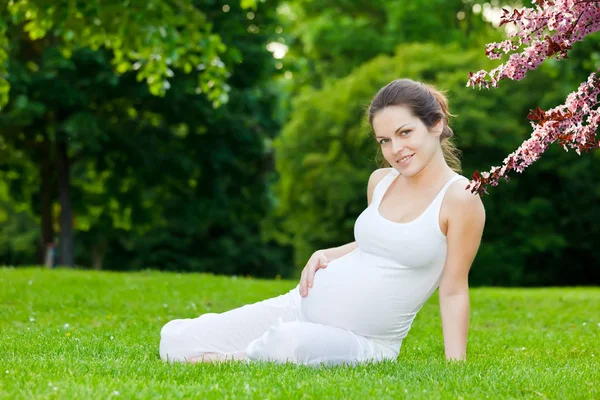 Όμορφη έγκυο γυναίκα στο πάρκο άνοιξη — Φωτογραφία Αρχείου