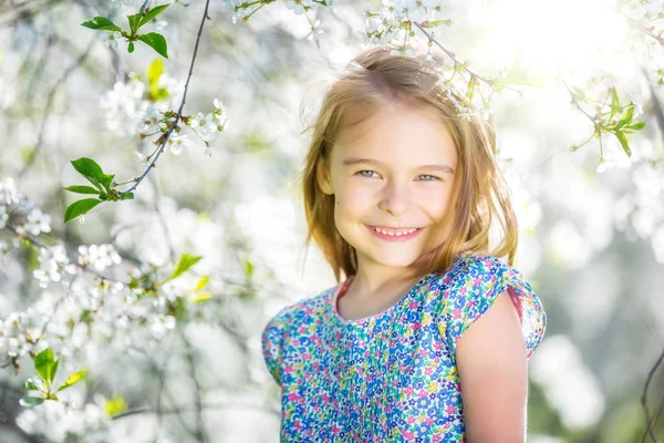 快乐的小女孩，在樱花盛开的花园里 — 图库照片
