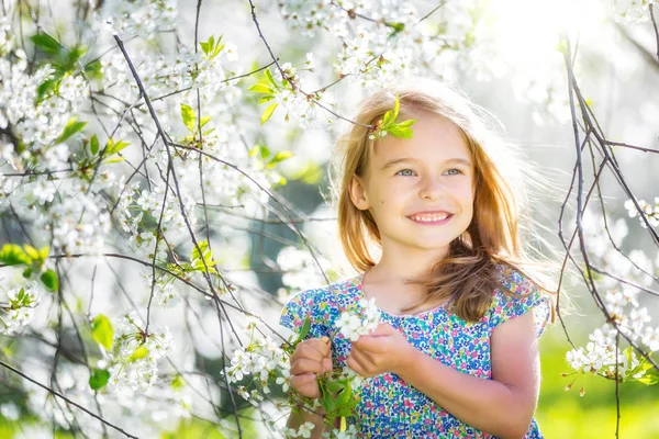 Glückliches kleines Mädchen im Kirschblütengarten — Stockfoto