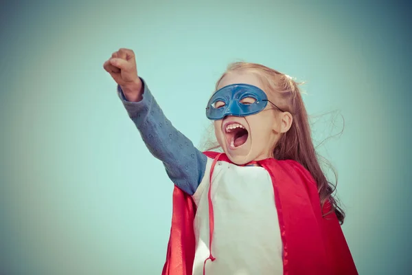 Vicces kis lány játszik a hatalom a szuperhős. — Stock Fotó