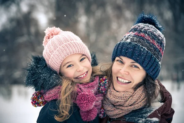 Mor och dotter leker i vinterparken — Stockfoto