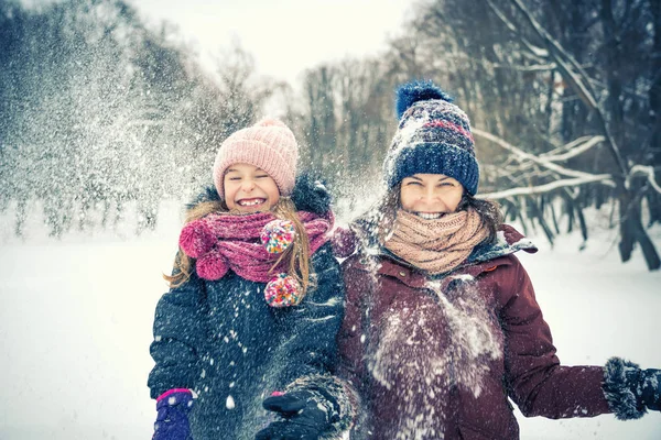 Mor och dotter leker i vinterparken — Stockfoto