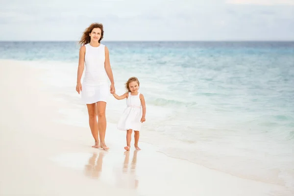 在马尔代夫海滩上散步的母亲和小女儿 — 图库照片