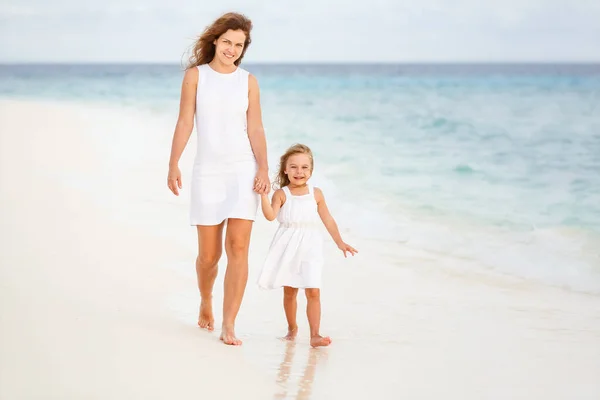 Mor och dotter går på stranden på Maldiverna — Stockfoto