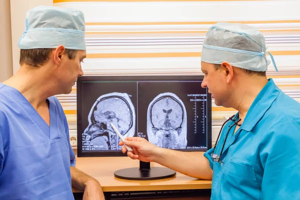 디스플레이에 뇌의 Mri 스캔 검사의 성숙한 의사 두 개 로열티 프리 스톡 이미지
