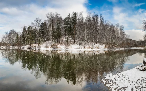 Zimní krajina s lesem na jezeře, mraky na obloze a — Stock fotografie