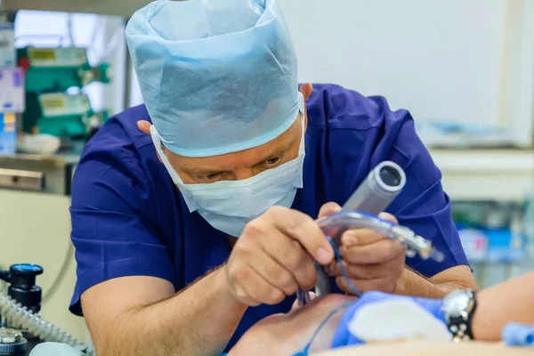 Анестезиолог проводит интубацию трахеи для пациента — стоковое фото